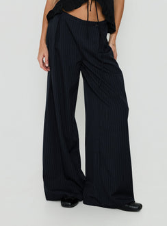 Showcasing Yuzima Micro Belt Pleated Pants Navy Pinstripe in womens regular pants with mid-rise front view of model wearing Princess Polly