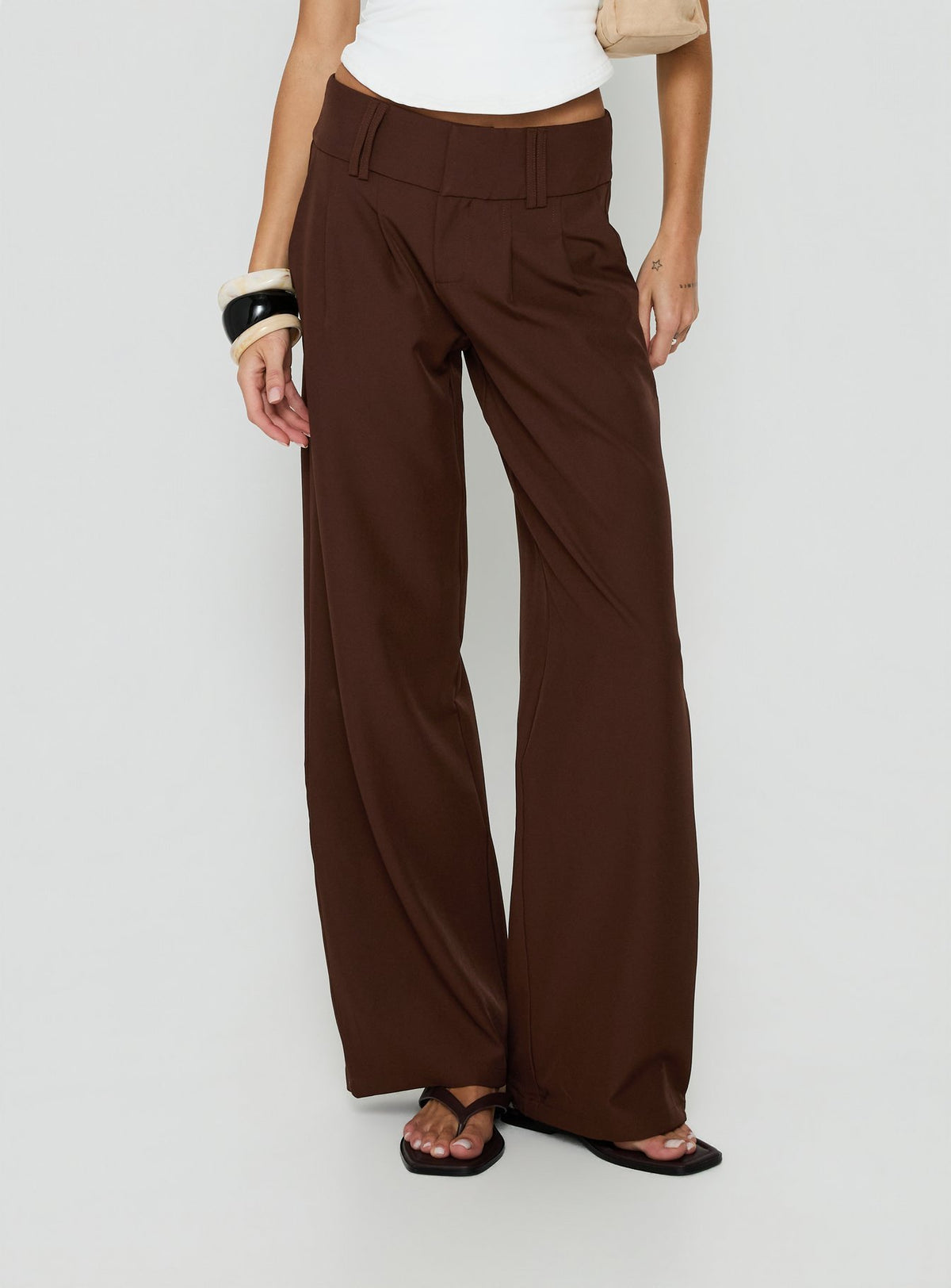 Showcasing the Two Lovers Low Rise Pants Chocolate in womens regular pants with belt and wide-leg silhouette front view of model wearing