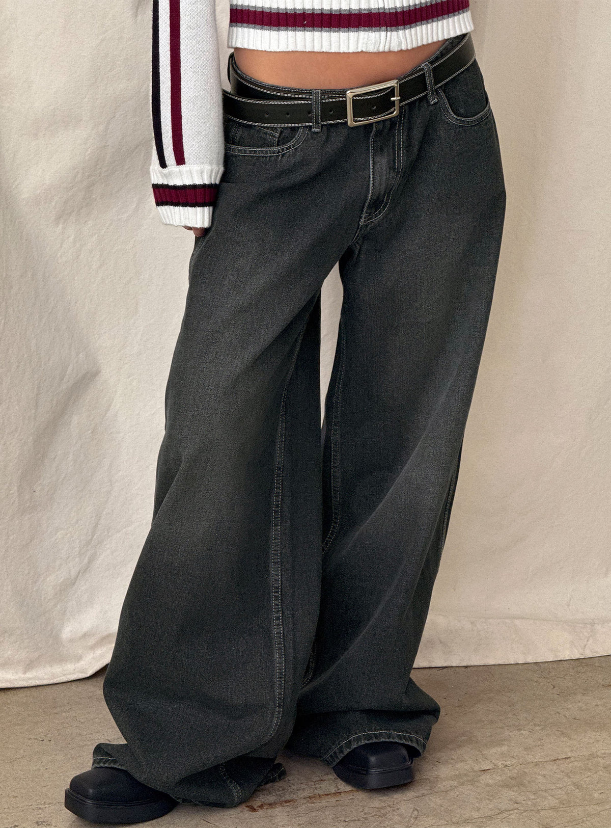 side view of model wearing Princess Polly Ramos Low Rise Wide Leg Jeans Dark Grey Wash Low Rise Jeans 