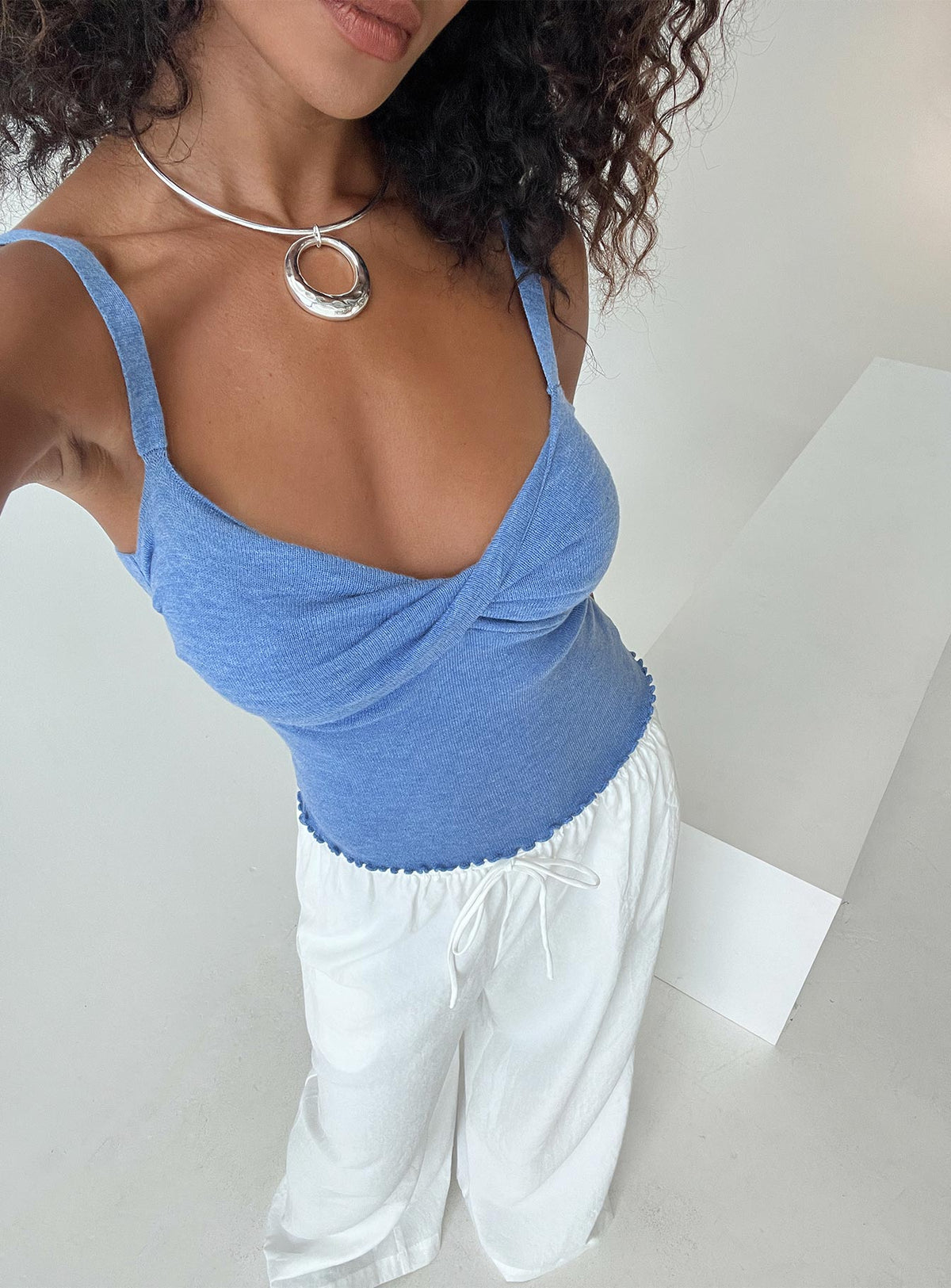 side view of model wearing Princess Polly Dalma Twist Top Blue Sleeveless Plunger 