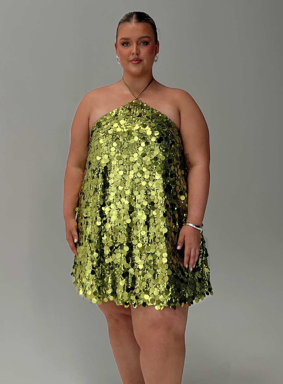side view of model wearing Princess Polly Fluorescents Halter Mini Dress Green Curve Asymmetric Neckline 