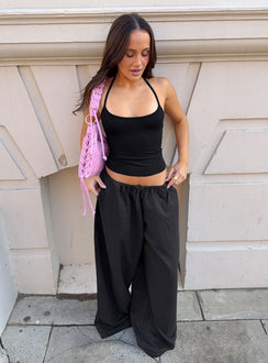Showcasing the Bungala Oversized Relaxed Pants Black Tall wide-leg womens regular pants in mid-rise front view of model wearing Princess Polly