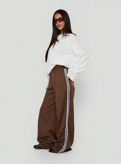 Showcasing the Fielder Track Pants Brown / Blue womens-regular-pants with high-rise side view of model wearing Princess Polly