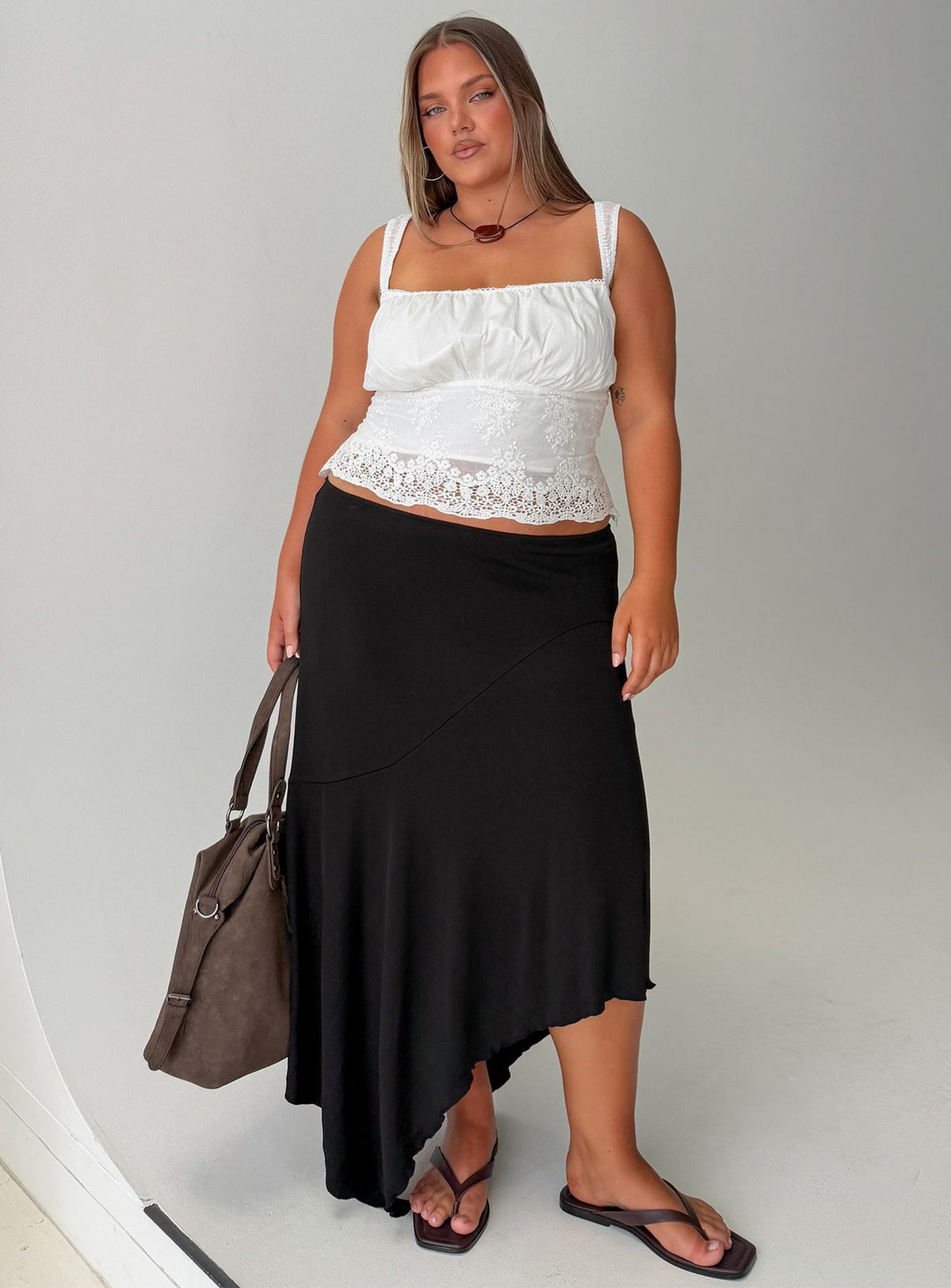 Featuring the Futura Asymmetrical Midi Skirt Black Curve in womens-skirts with midi length front view of model wearing Princess Polly