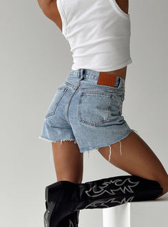 side view of model wearing Princess Polly Xena Denim Shorts Tall High Waisted Shorts 