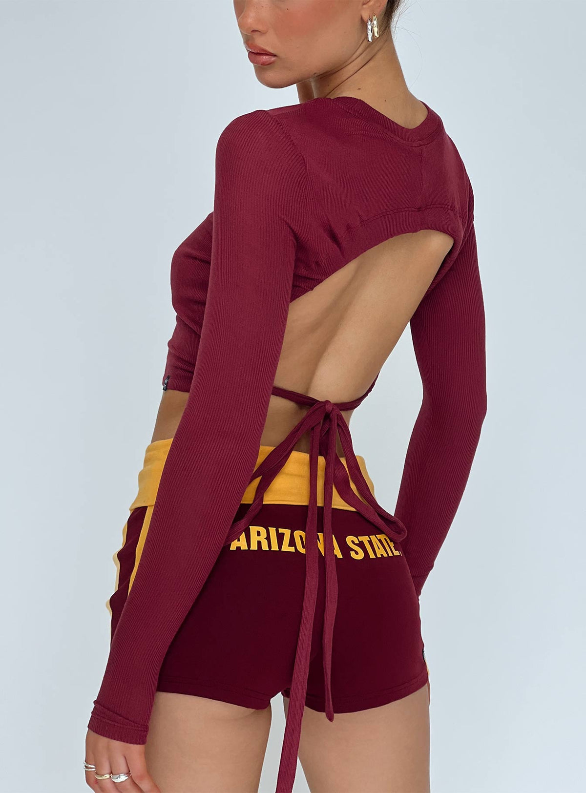 back view of model wearing Princess Polly ASU Foldover Shorts Maroon Low Rise Shorts 