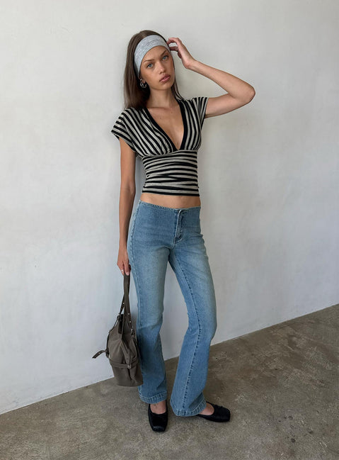 Showcasing the Flow Rider No Waist Low Rise Bootleg Jean Vintage Blue Wash womens-jeans with low-rise waist front view of model wearing Princess Polly