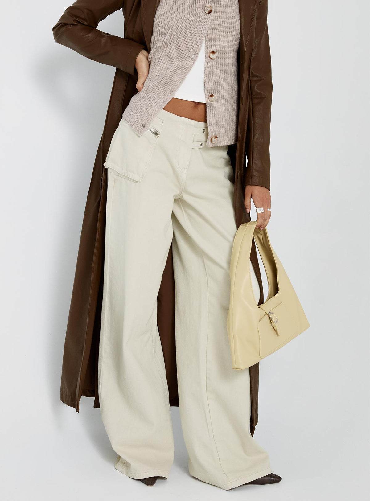 side view of model wearing Princess Polly Paltrow Mid Rise Wide Leg Cargo Jeans Cream Petite Low Rise Jeans 