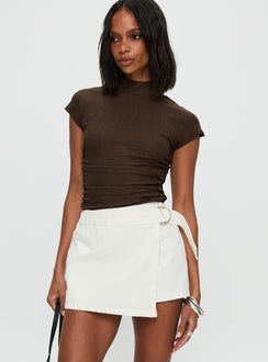   side view of model wearing Princess Polly Elinora Wrap Mini Skirt White Mini Skirts Skirts 