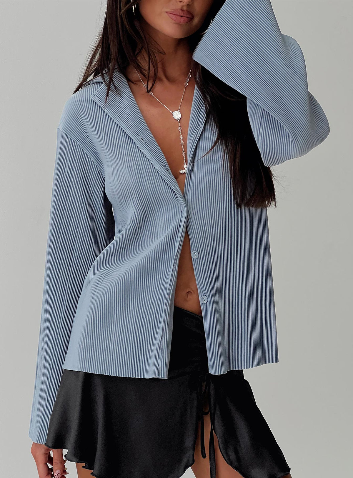 side view of model wearing Princess Polly Louie Pleated Shirt Blue Full Sleeves V-Neck 