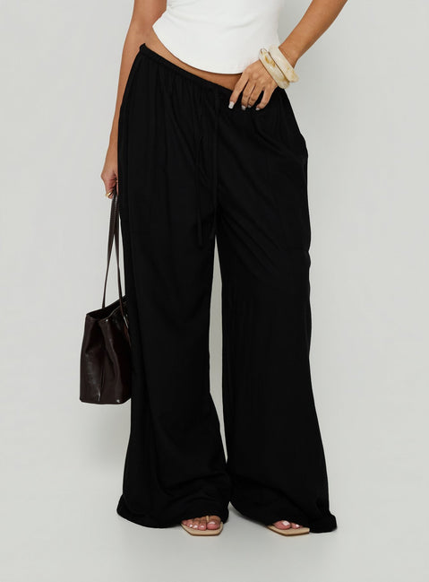 Showcasing Peacemaker Tie Waist Relaxed Pants Black in womens-regular-pants with mid-rise detail front view of model wearing