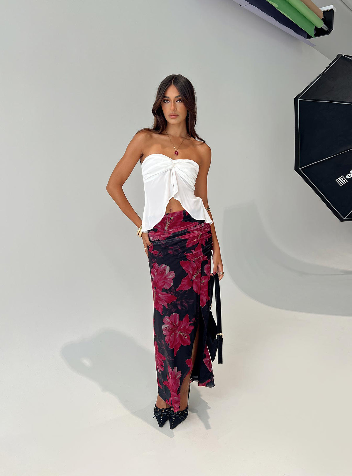   side view of model wearing Princess Polly Cooperi Maxi Skirt Black / Red Floral Maxi 