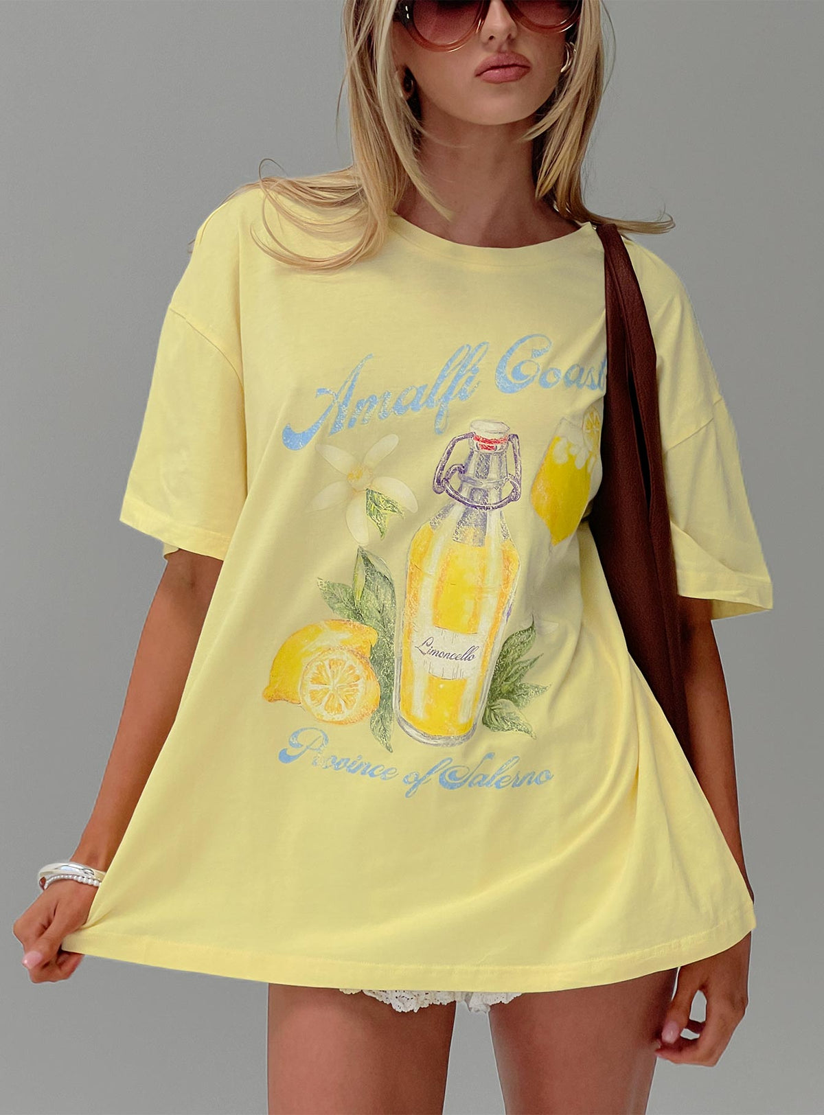 front view of model wearing Princess Polly Amalfi Coast Oversized Graphic Tee Pastel Yellow Half Sleeves Crew Neck 