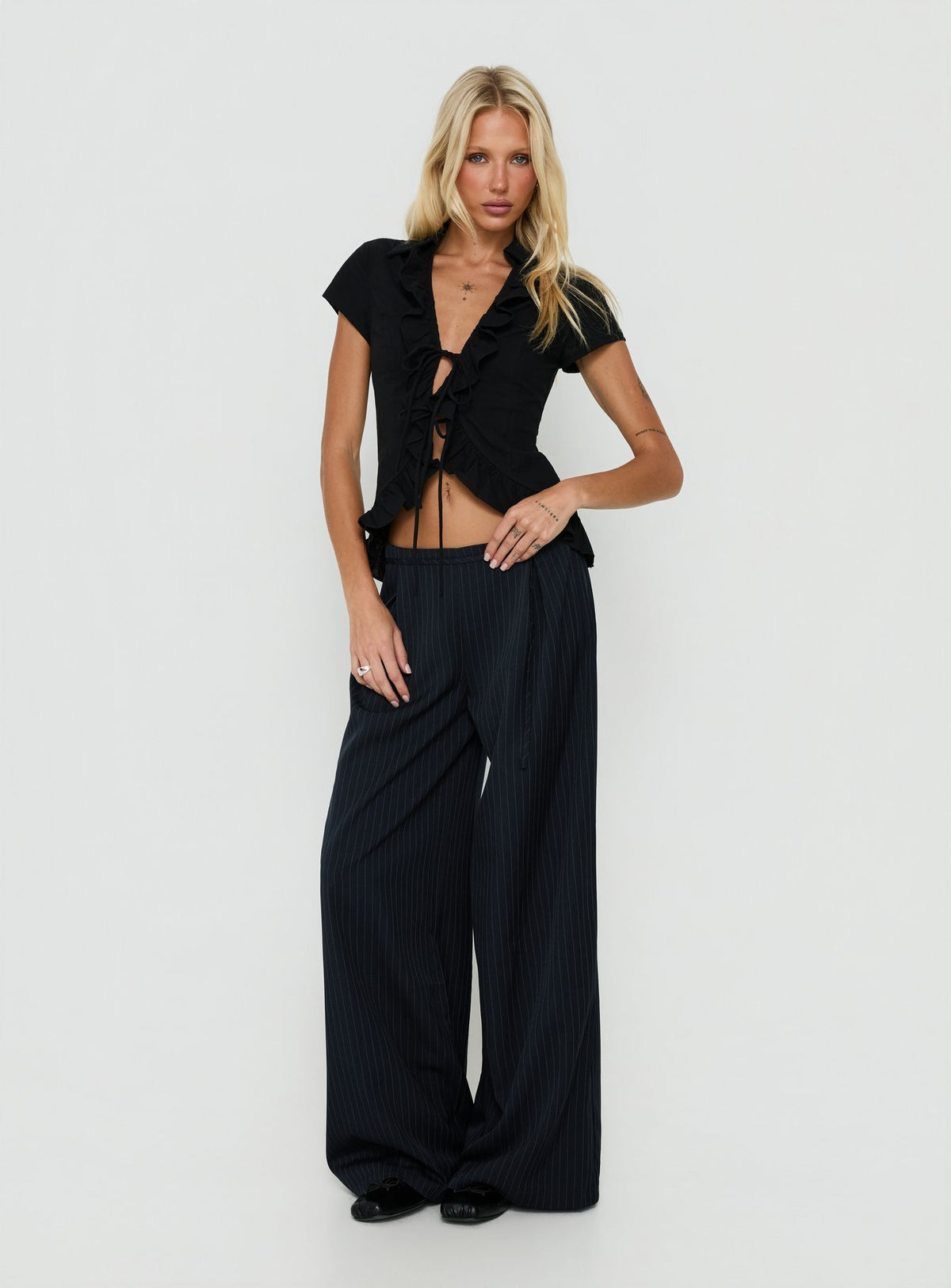 Featuring Yuzima Micro Belt Pleated Pants Navy Pinstripe in womens regular pants with mid-rise detail view of model wearing Princess Polly