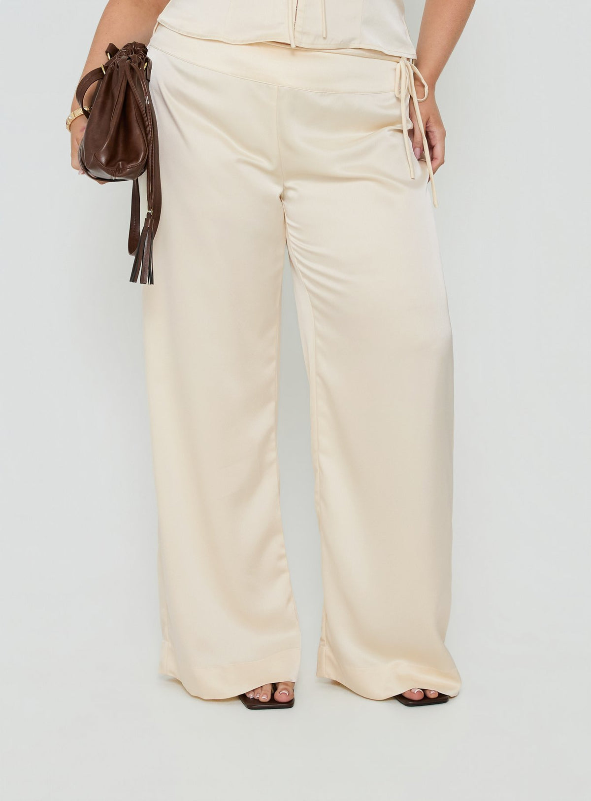 Showcasing the Aubrette Satin Tie Pants Cream Curve womens-regular-pants with high-rise, belt detail and wide-leg cut detail Princess Polly
