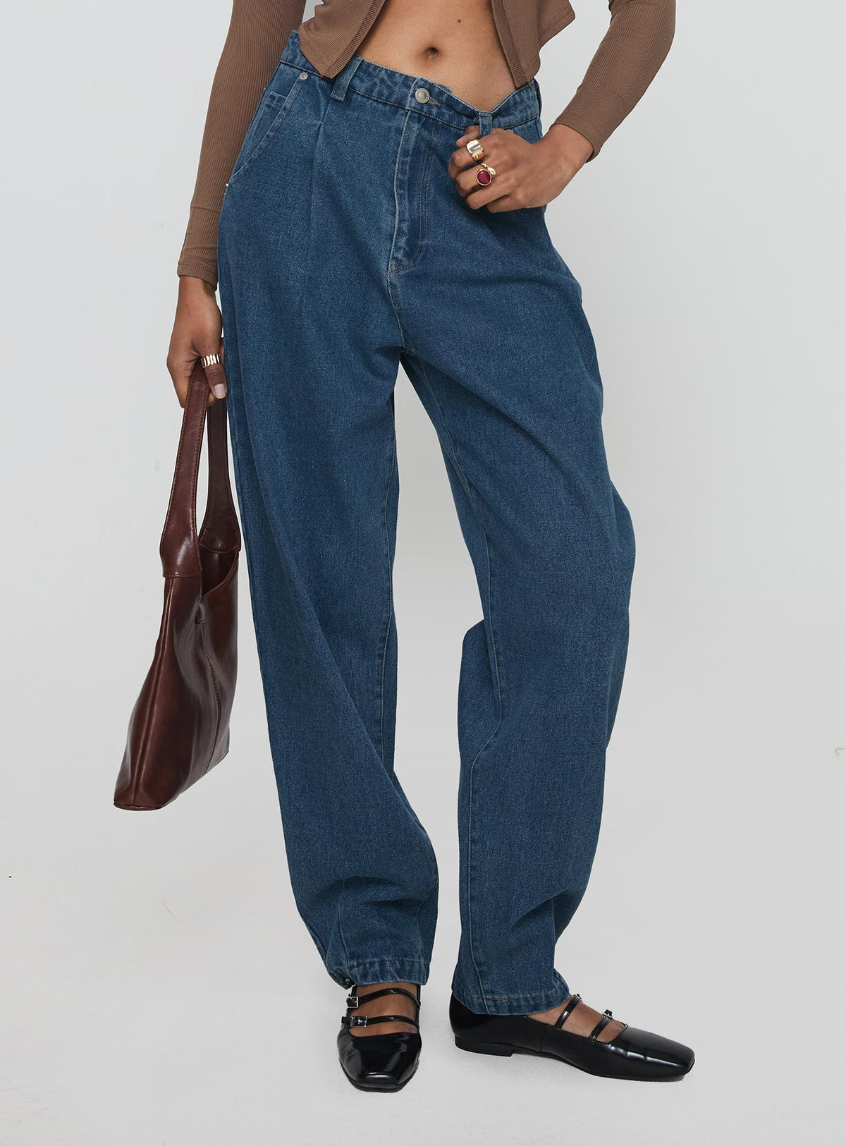 side view of model wearing Princess Polly Forestier Mid Rise Barrel Leg Pin Tuck Jeans Mid Blue High Rise Jeans Jeans 