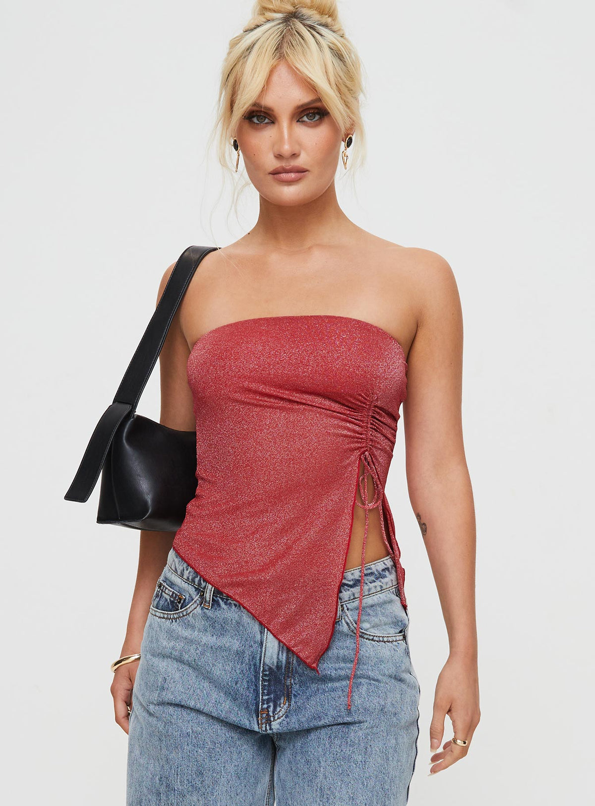 Front view of model wearing  front Princess Polly Sleeveless Asymmetric Neckline  Dessy Strapless Top Red Glitter