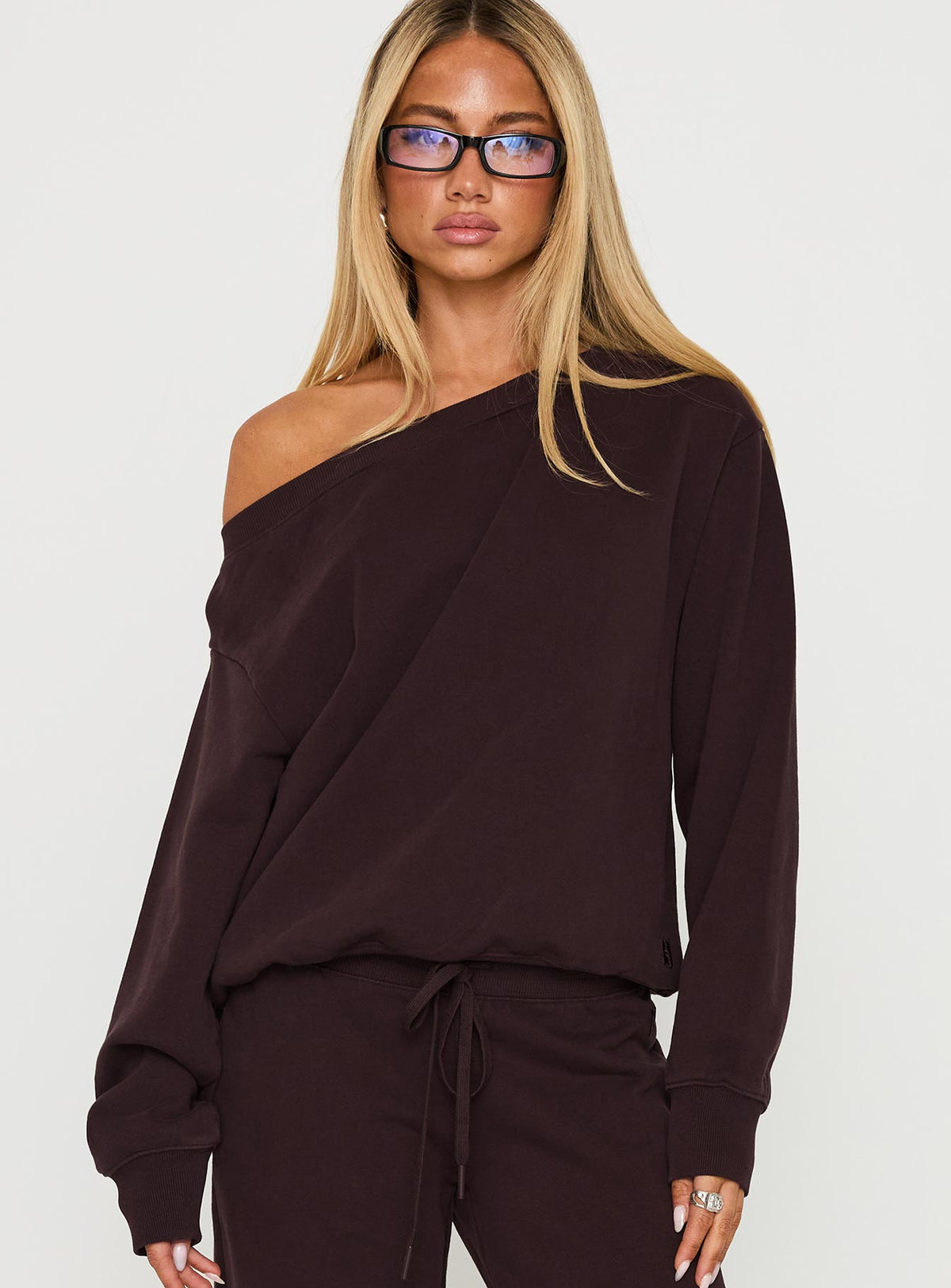 Showcasing the Wellness Off The Shoulder Jumper Brown in women's jumpers with long length and oversized fit front view of model wearing Princess Polly