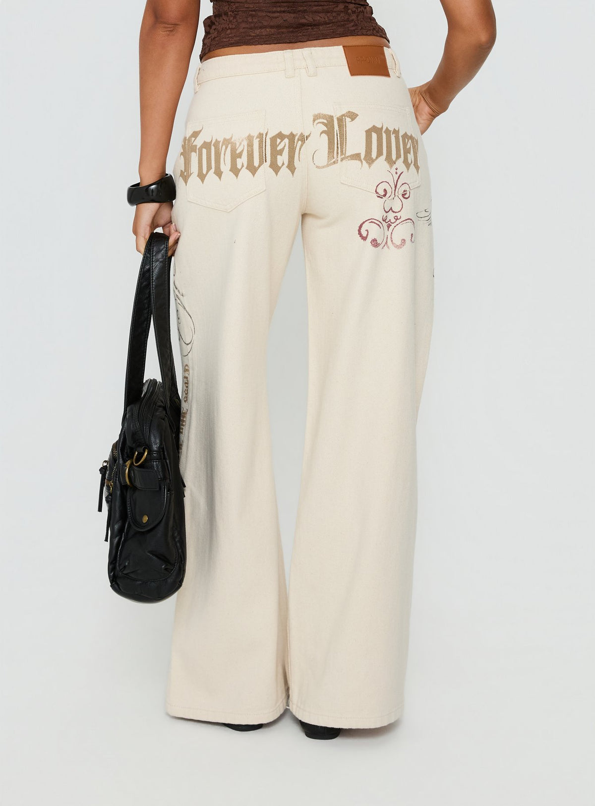 back view of model wearing Princess Polly Than Forever Love Graphic Denim Jeans Cream Low Rise Jeans Jeans 