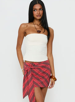   side view of model wearing Princess Polly Lindsy Tie Side Mini Skirt Red Multi Mini Skirts Skirts 