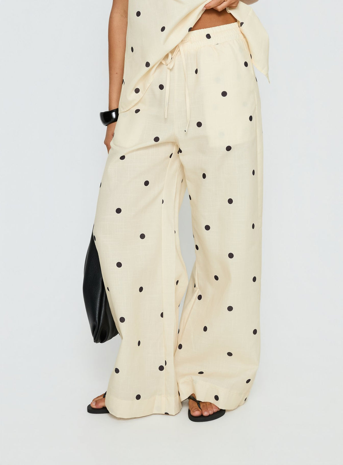 Crafted from cornsilk fabric, Bellara Tie Waist Pants Yellow Polka womens regular pants feature mid-rise and belt detail view of model wearing Princess Polly