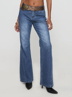 side view of model wearing Princess Polly Leslee Mid Rise Flare Jean Mid Wash Blue Mid Rise Jeans Jeans 