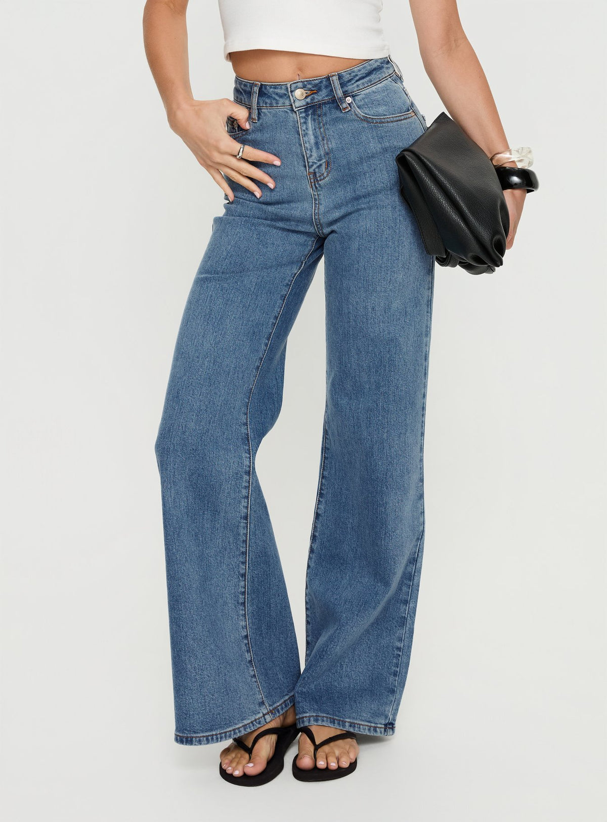 front view of model wearing Princess Polly Thearlie High Rise Flared Jeans Mid Blue Wash High Rise Jeans Jeans 