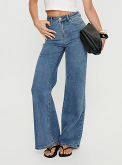 front view of model wearing Princess Polly Thearlie High Rise Flared Jeans Mid Blue Wash High Rise Jeans Jeans 