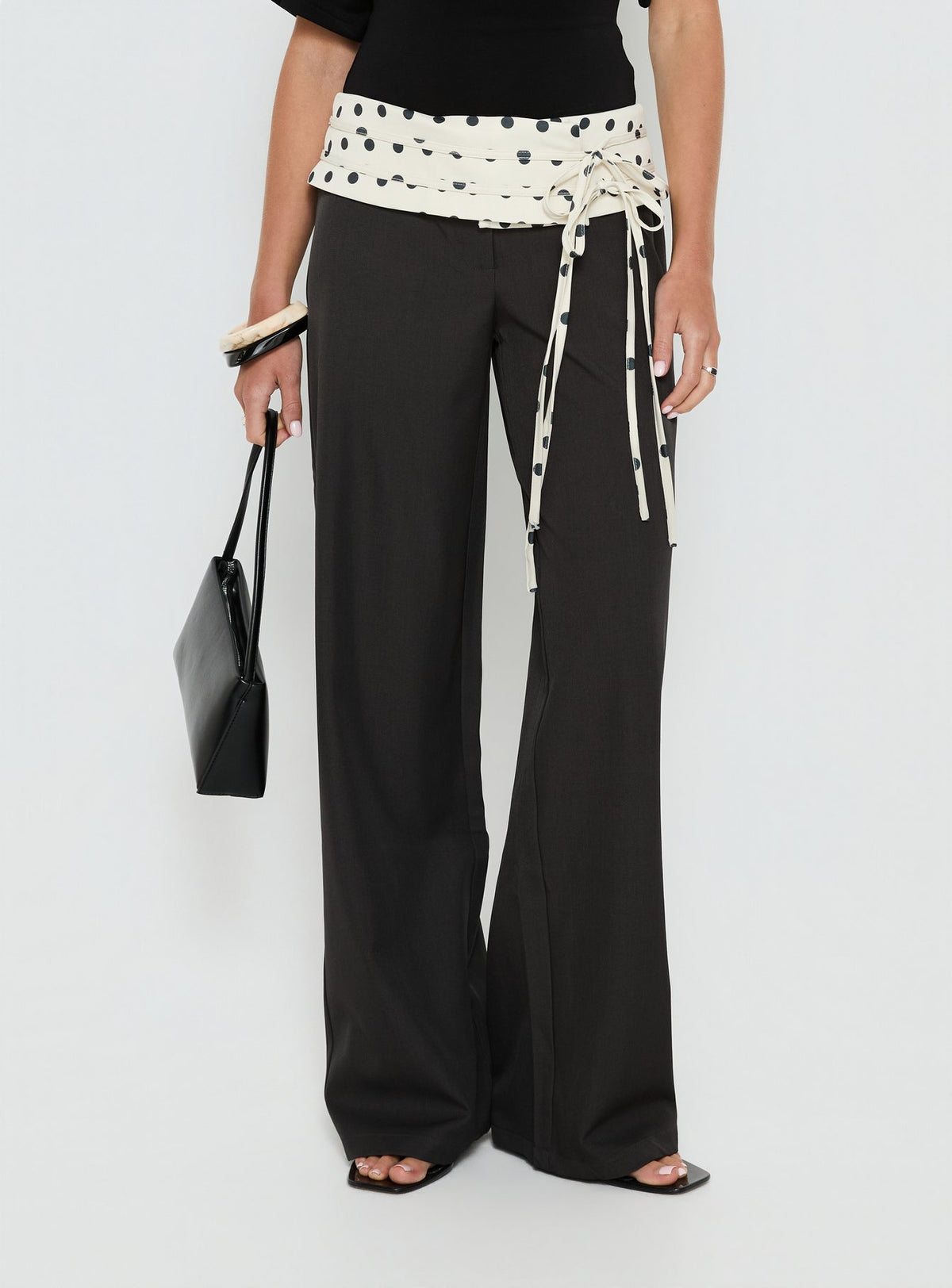 side view of model wearing Princess Polly Seneca Wrap Pants Charcoal Polka Dot Mid Rise Pants Pants 