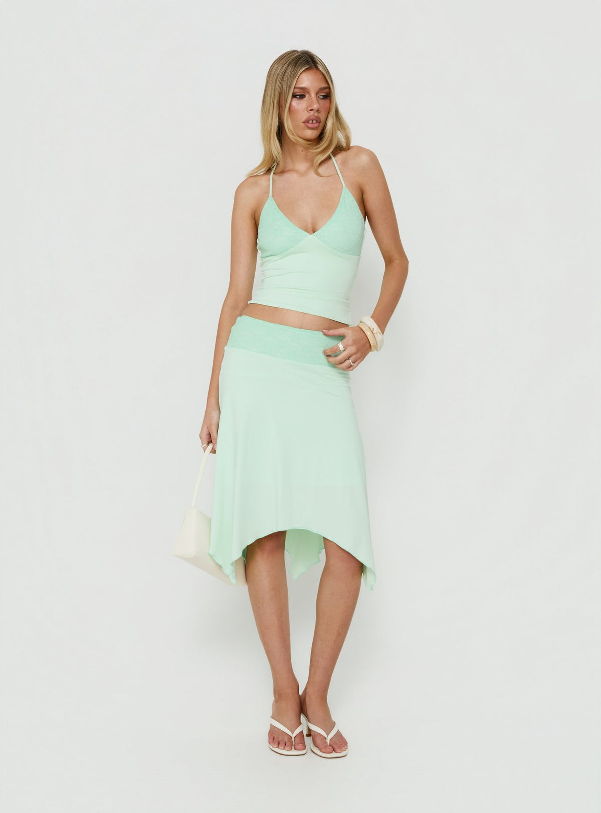 Showcasing the Natabelle Lace Detail Midi Skirt in Mint, a womens-skirts piece with asymmetry and fitted fit Princess Polly
