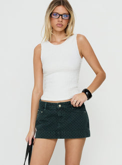 Featuring the Warna Low Rise Denim Mini Skirt Polka Dot womens-skirts with mini length, polkadot print, dark wash, aline shape, fitted fit, and frayed hem front view of model wearing Princess Polly