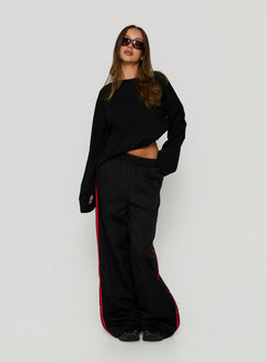 Showcasing Fielder Track Pants Black / Red in womens-regular-pants with mid-rise detail view of model wearing