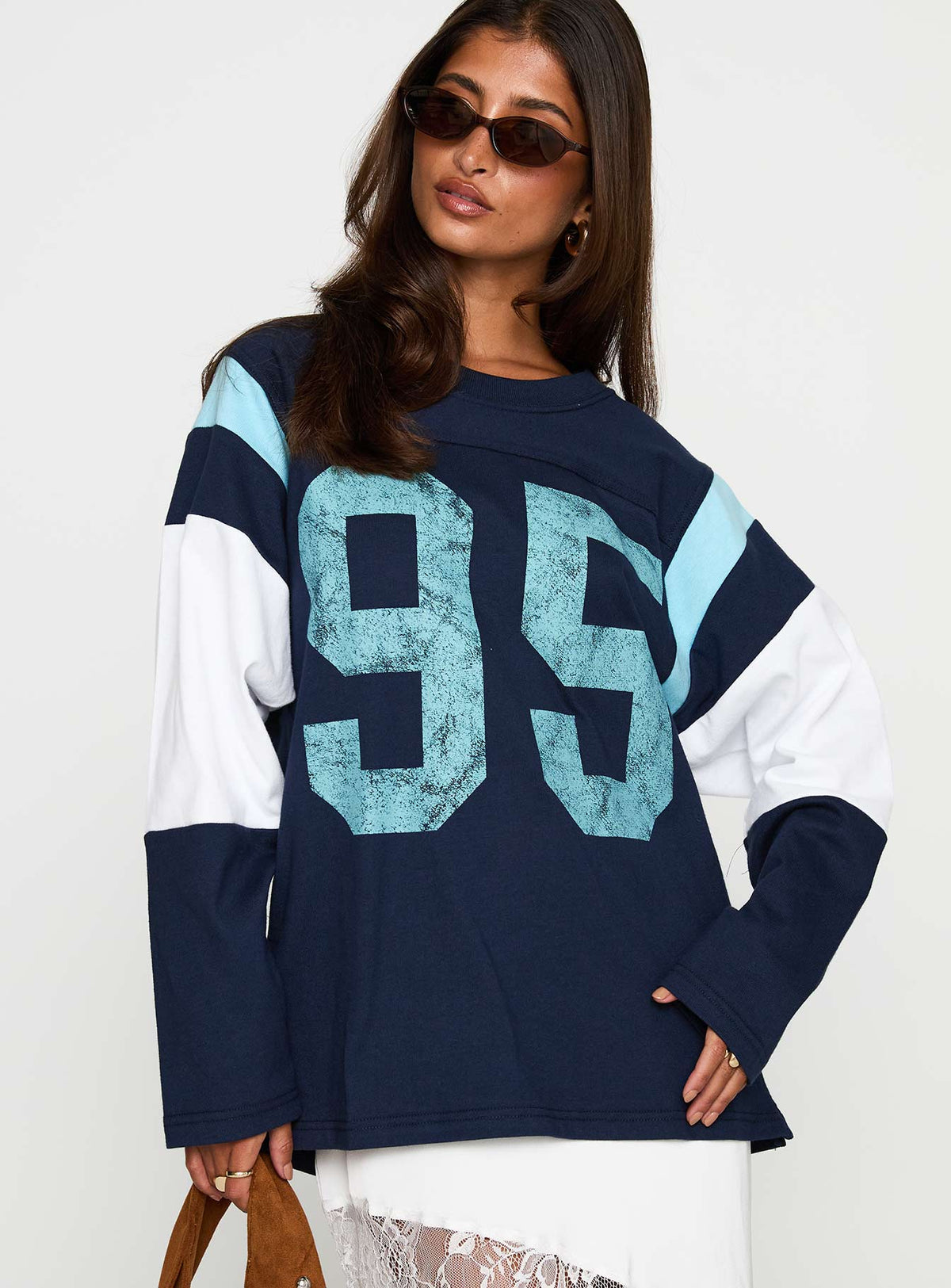 side view of model wearing Princess Polly Collegiate Queen Long Sleeved Top Navy Full Sleeves Crew Neck 