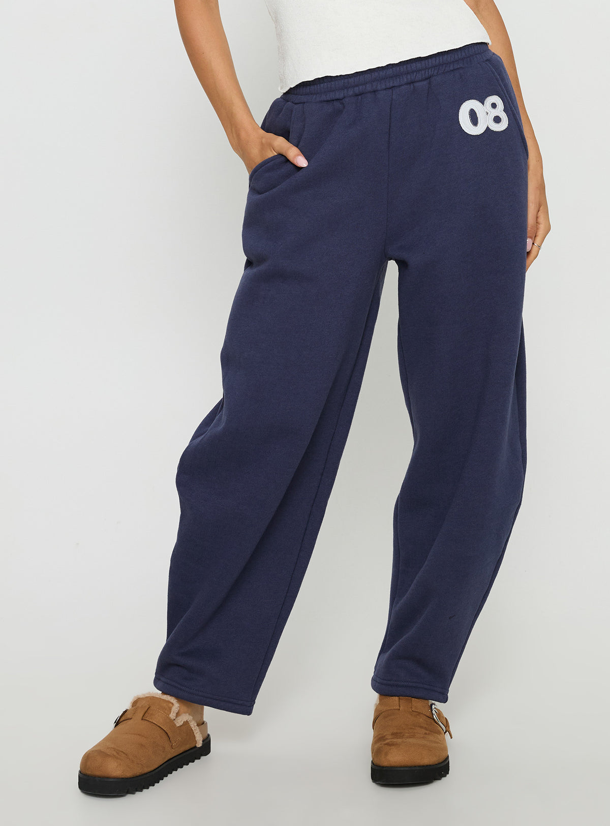 side view of model wearing Princess Polly Route 08 Barrel Track Pant Navy Mid Rise Pants Pants 