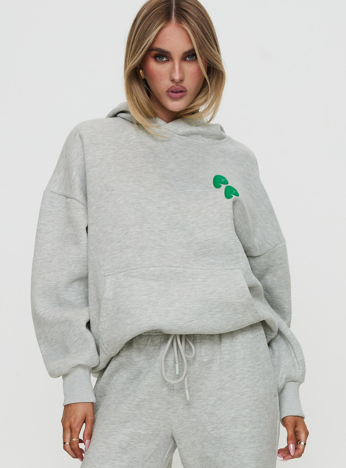 front view of model wearing Princess Polly Princess Polly Hooded Sweatshirt Bubble Text Grey Marle / Green Jumpers 