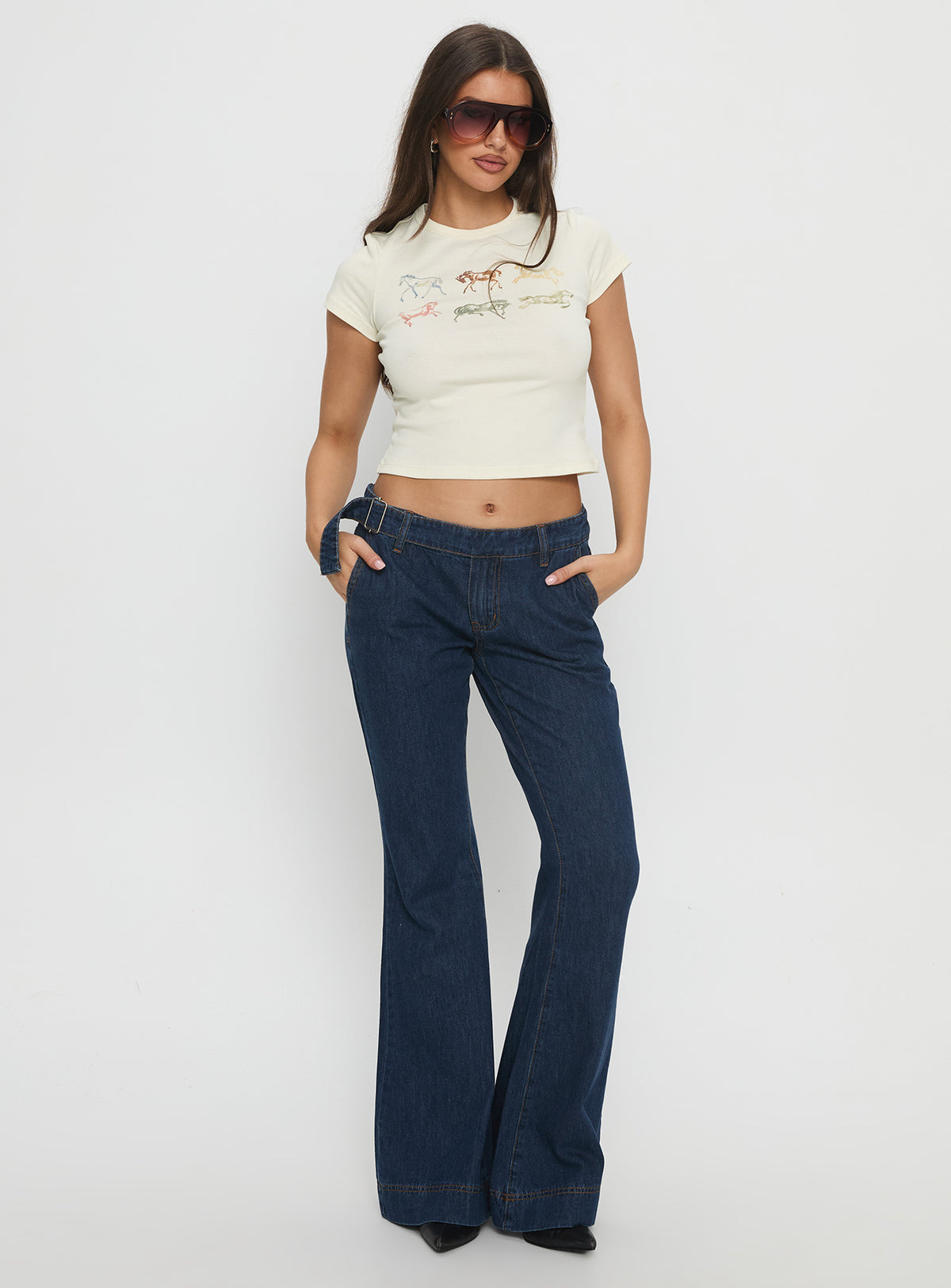 side view of model wearing Princess Polly Acapulco Low Rise Flare Jeans Dark Blue Wash Low Rise Jeans Jeans 