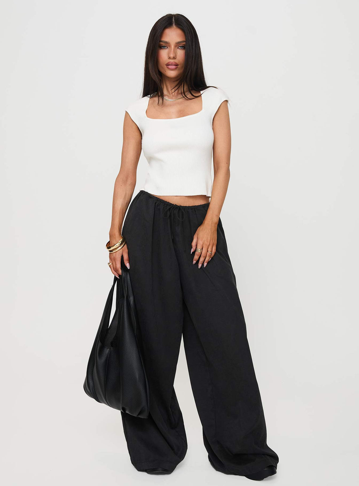 Showcasing the Bungala Oversized Relaxed Pants Black Tall wide-leg womens regular pants in mid-rise front view of model wearing Princess Polly