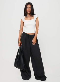 Showcasing the Bungala Oversized Relaxed Pants Black Tall wide-leg womens regular pants in mid-rise front view of model wearing Princess Polly