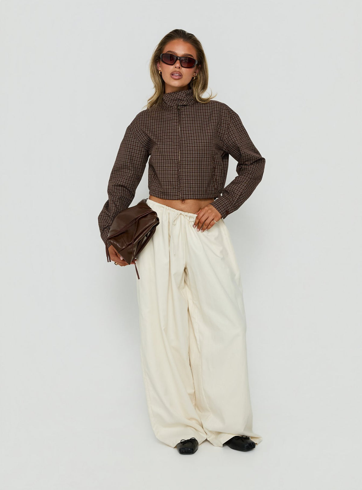 Crafted from ivory fabric the Bungala Oversized Relaxed Pants Petite womens-regular-pants with high-rise waist and wide-leg cut side view of model wearing Princess Polly