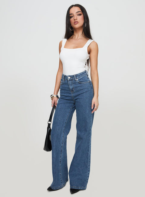 side view of model wearing Princess Polly Lucille High Rise Flared Jeans Mid Wash High Rise Jeans Jeans 