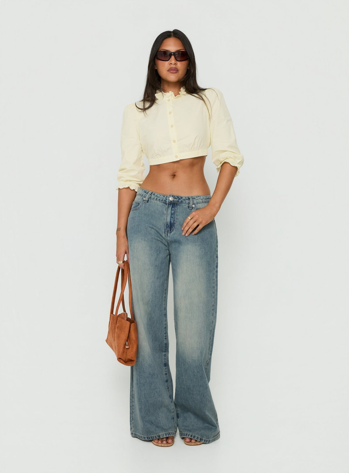 Discover the Karlos Low Rise Cinched Baggy Jeans Vintage Mid Blue Wash in womens-jeans featuring abstract print front view of model wearing Princess Polly