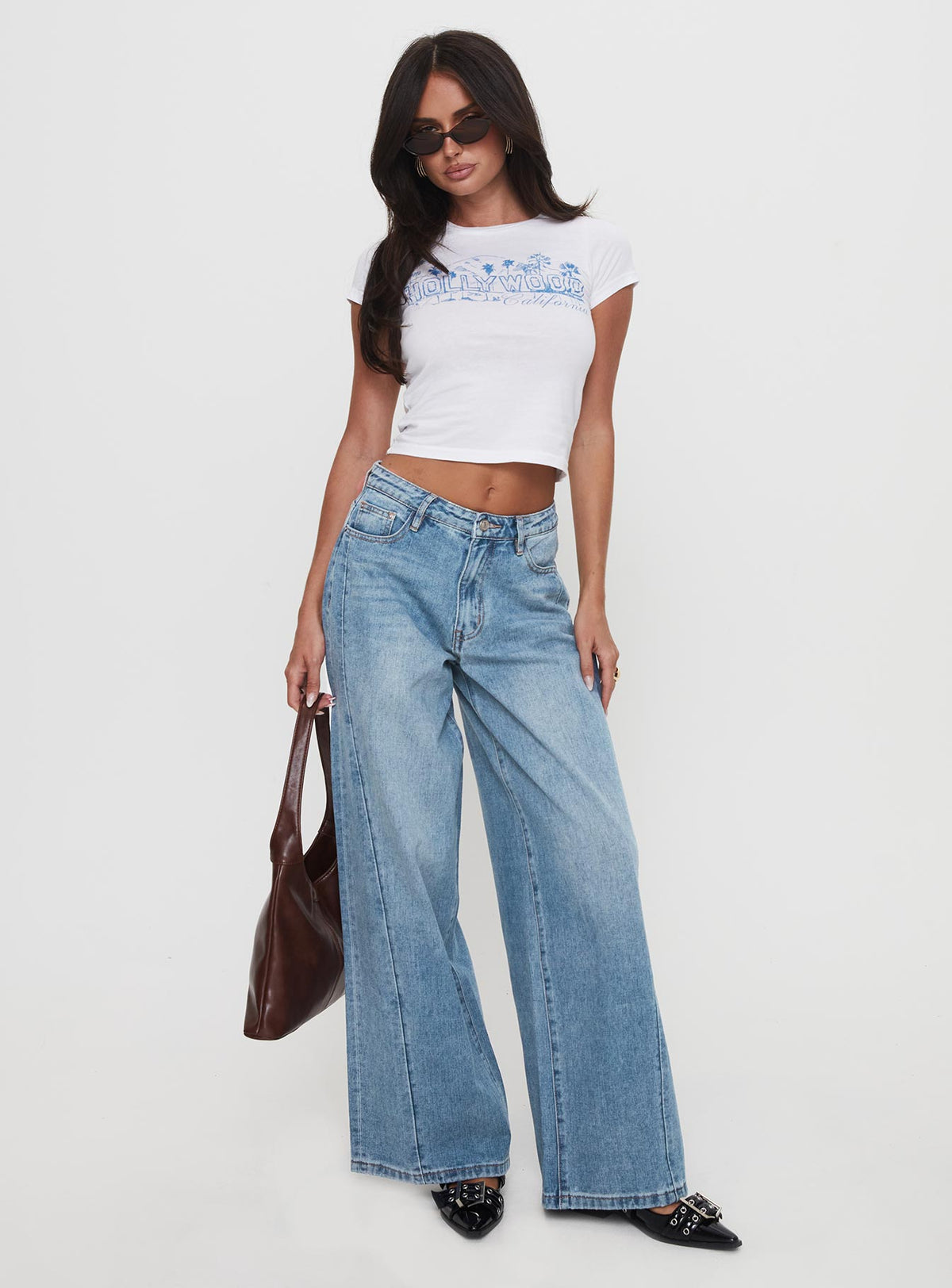 side view of model wearing Princess Polly Ringer Low Rise Wide Leg Jeans Blue Mid Rise Jeans Jeans 