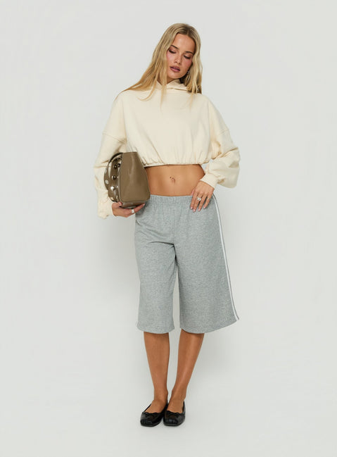 Crafted from beige fabric, the Mayse Bubble Hem Cropped Hoodie Cream womens jumpers in short length detail view of model wearing Princess Polly
