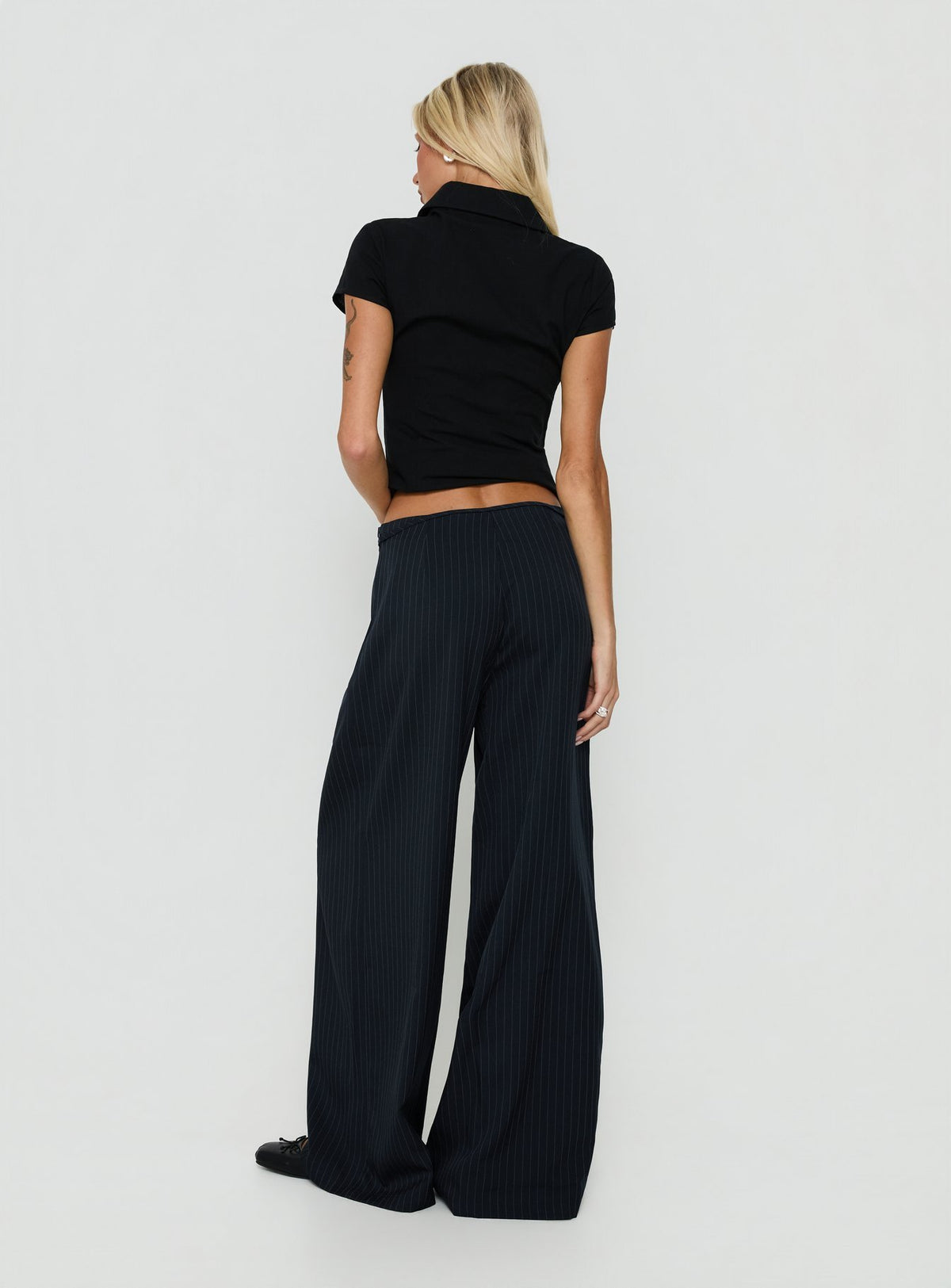 Styled Yuzima Micro Belt Pleated Pants Navy Pinstripe in womens regular pants with mid-rise back view of model wearing Princess Polly