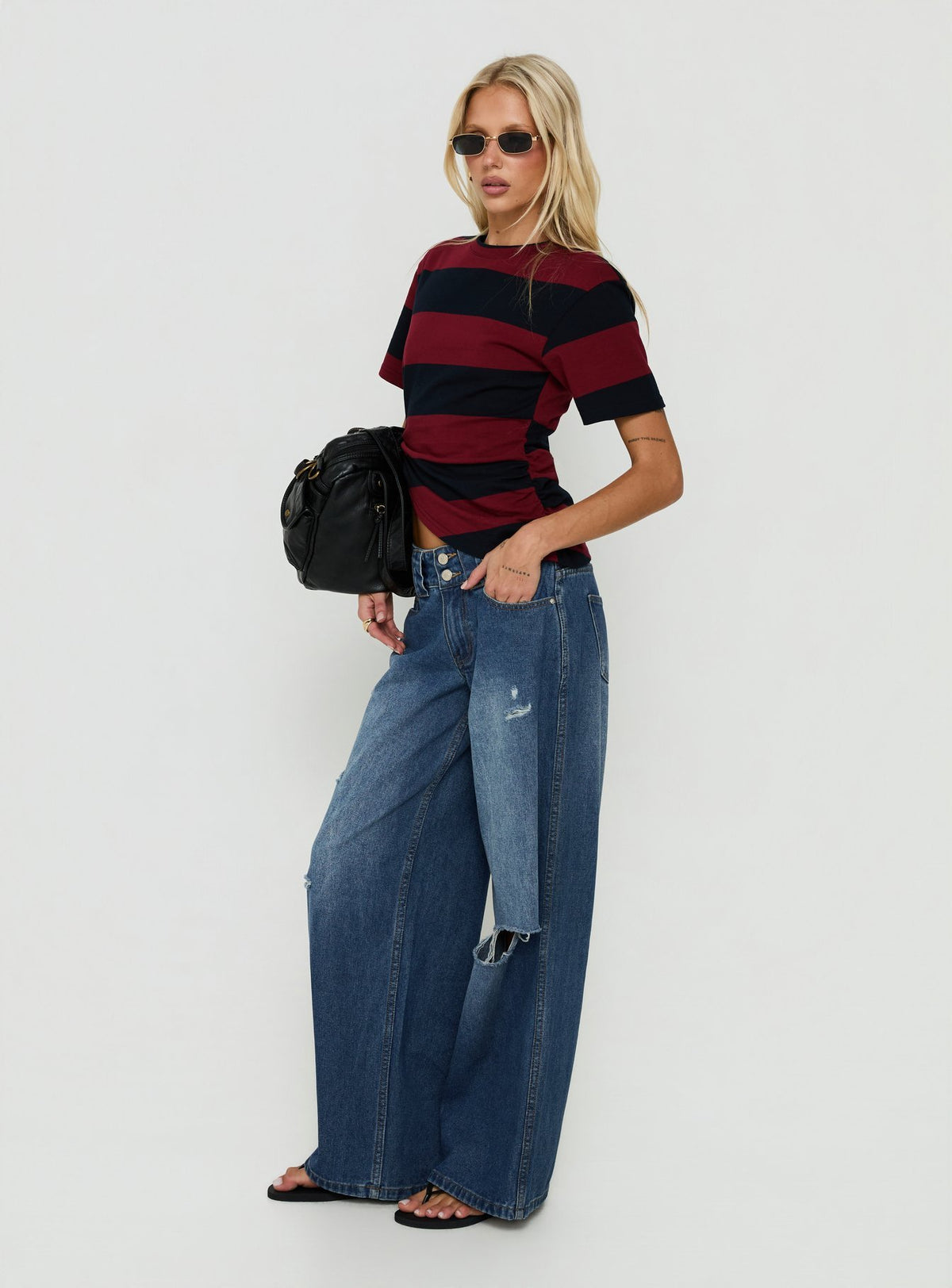 Featuring the Ramos Low Rise Double Button Distressed Wide Leg Denim Jeans in Mid Blue womens jeans side view of model wearing Princess Polly