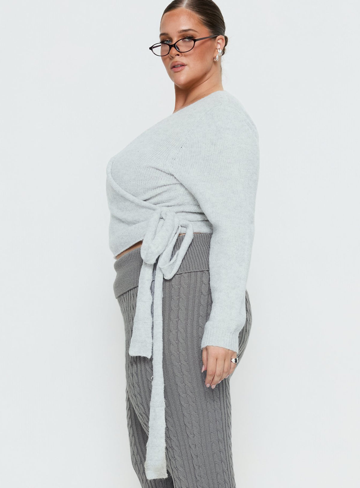 Designed with the Tonee Wrap Knit Cardigan Grey Curve in a short length womens jumper with v-neck and oversized fit side view of model wearing Princess Polly