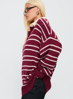 Showcasing the Rising Sun Jersey Crimson womens jumpers with long oversized fit, striped print, and v-neck collar side view of model wearing Princess Polly
