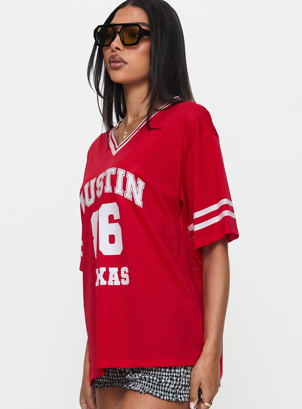 side view of model wearing Princess Polly Austin Texas Sports Jersey Top Red Half Sleeves V-Neck 