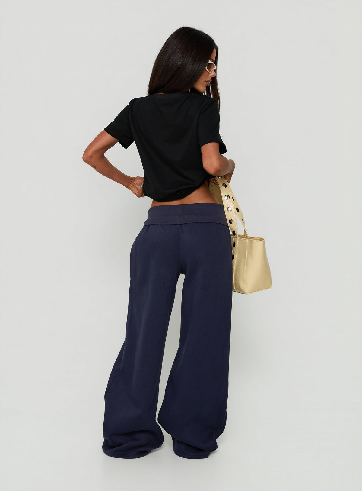 Designed in navy, the Lockie Foldover Baggy Track Pants womens-regular-pants with low-rise back view of model wearing Princess Polly