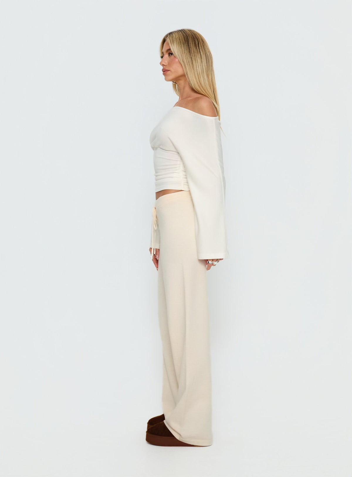 side view of model wearing Princess Polly Felisha Low Waist Knit Pants White Mid Rise Pants Pants 